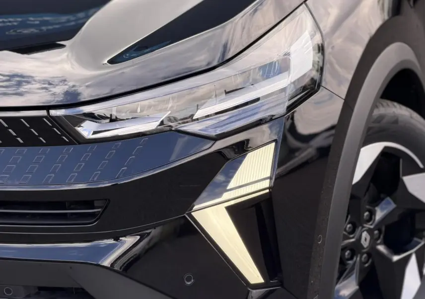 Gros plan sur l'avant droit du Renault Captur noir étoilé, mettant en valeur les phares LED et la jante aluminium 18 pouces.
