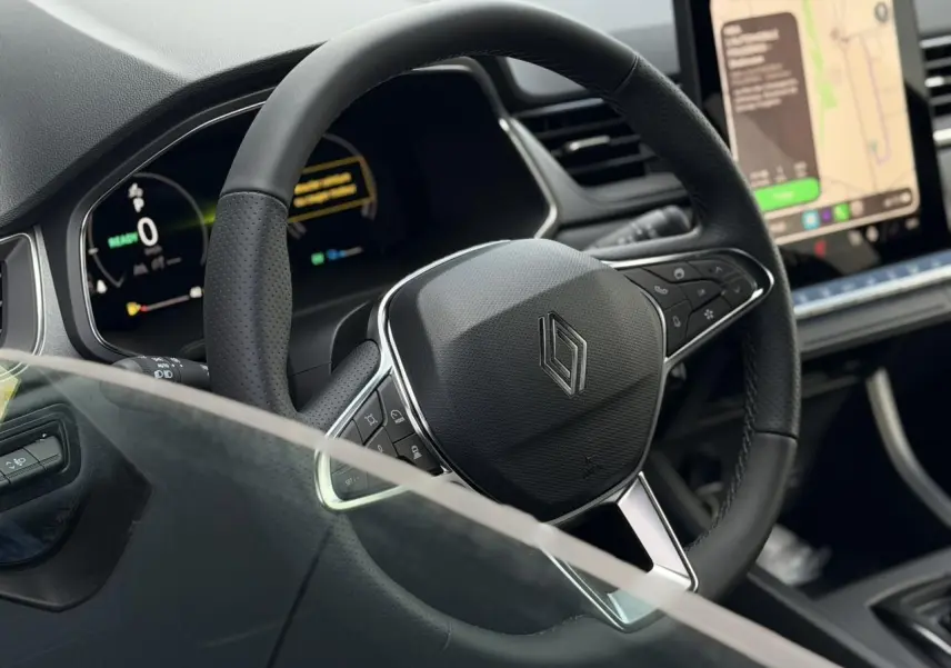 Gros plan sur le volant noir texturé du Renault Captur 2026 avec tableau de bord numérique et écran tactile.