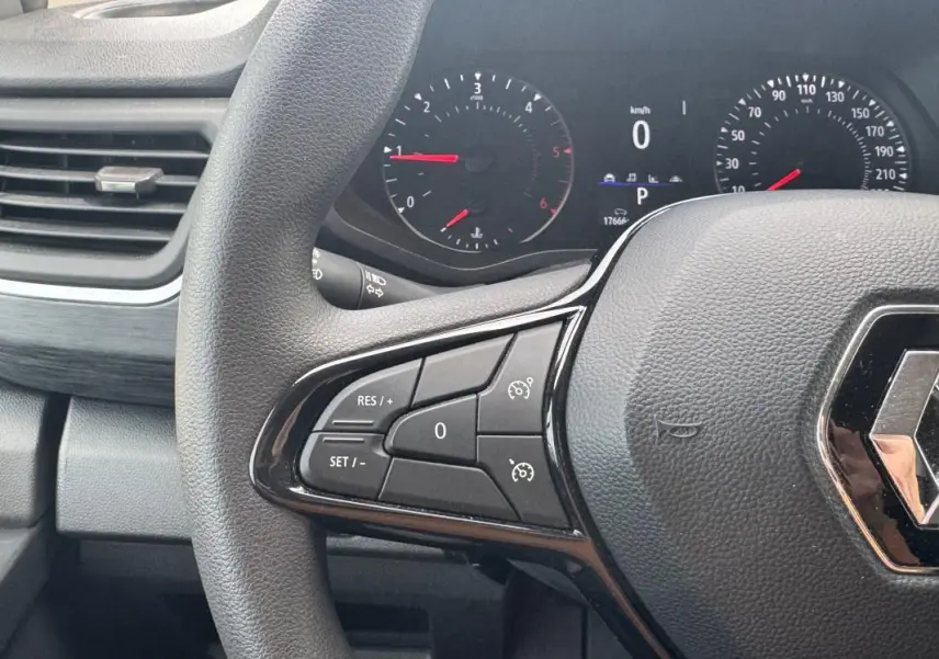 Vue rapprochée du volant gris foncé du Renault Trafic Fourgon 2024 avec commandes intégrées au volant.