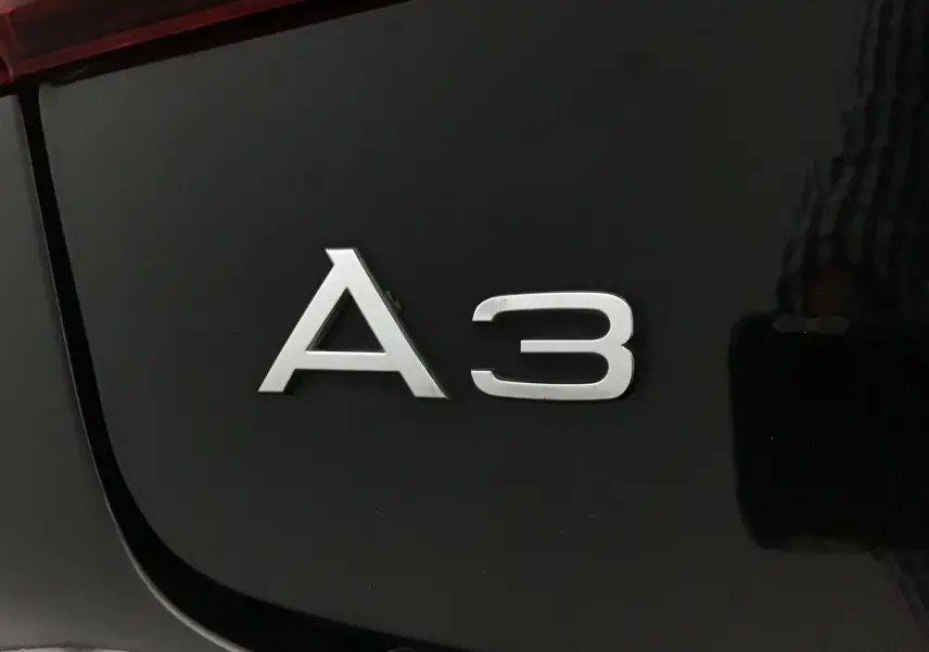 Gros plan sur l'emblème A3 argenté sur la carrosserie noire brillante d'une Audi A3 Cabriolet 2020