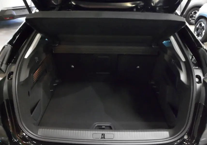 Coffre ouvert en vue arrière d'une Citroën C4 Hybride 136 e-DCS6 Max noir Perla, espace de chargement spacieux et propre.