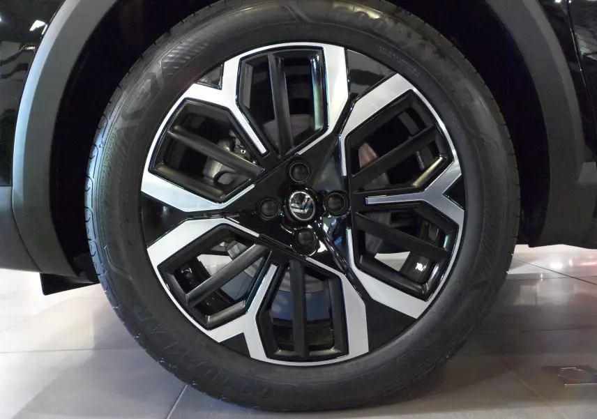 Gros plan sur la jante noire et argentée au design géométrique du Citroën C4 Hybride 2025 Noir Perla.