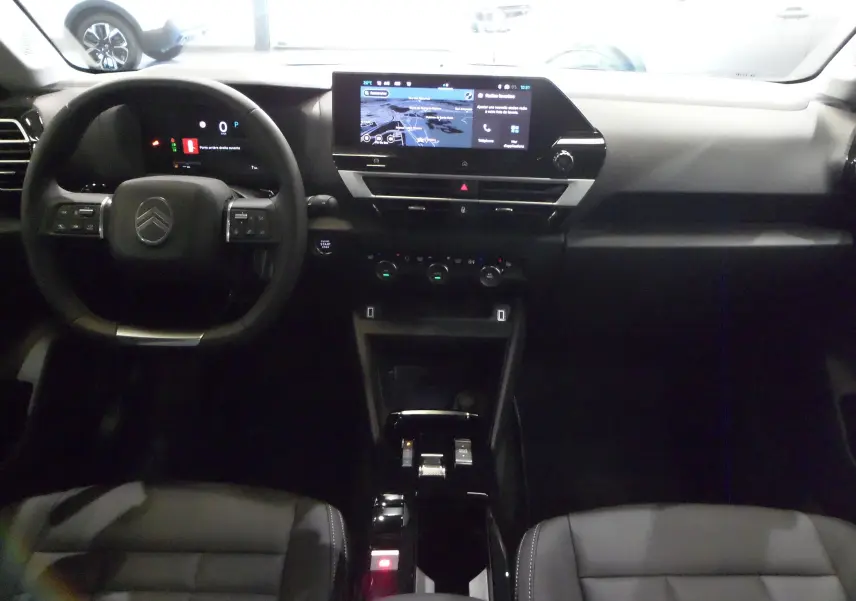 Intérieur de la Citroën C4 Hybride 136 e-DCS6 Max 2025, vue du tableau de bord avec écran tactile et volant noir.