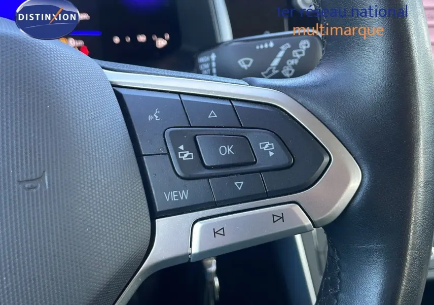 Gros plan sur les commandes multifonctions côté gauche du volant noir du Volkswagen Taigo gris cendre 2022.