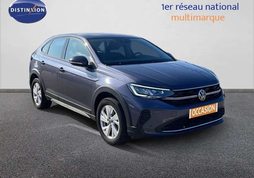 Volkswagen Taigo gris cendre en 3/4 avant droit, avec jantes alliage et calandre noire brillante.