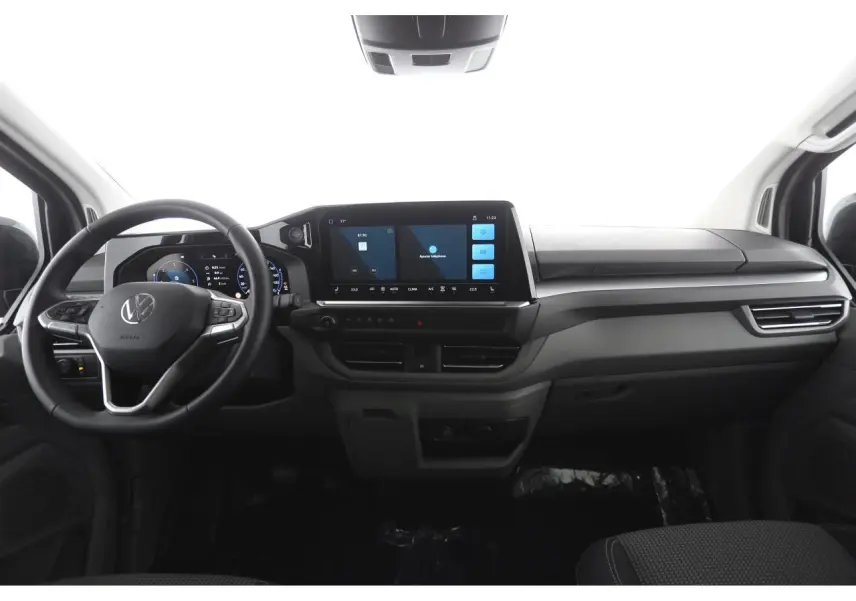 Vue intérieure frontale du Volkswagen Transporter 2025, tableau de bord moderne avec écran tactile 13 pouces et volant multifonction.