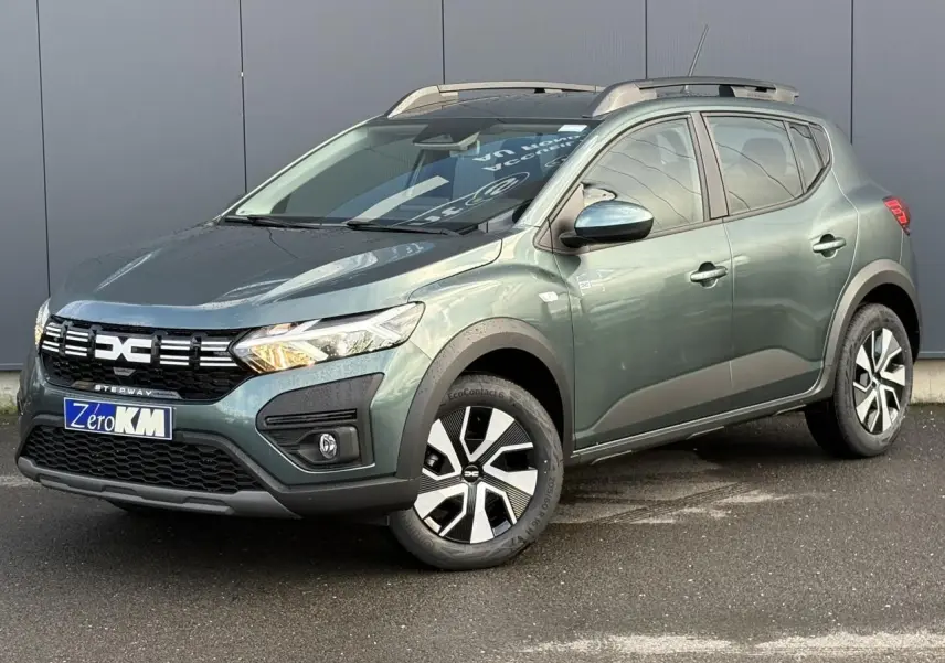 Dacia Sandero Stepway TCE 90 vert cèdre en 3/4 avant droit avec barres de toit et jantes spécifiques.