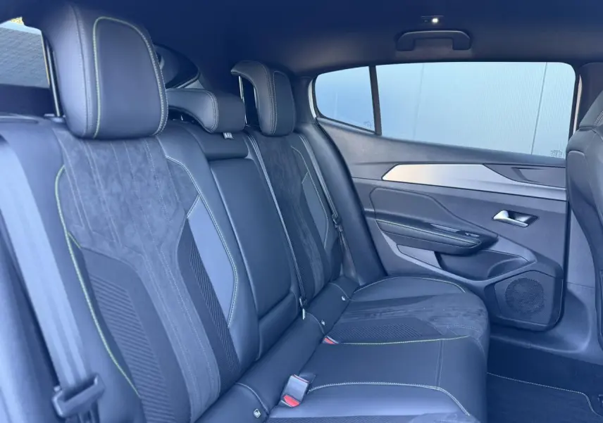 Vue latérale droite de la banquette arrière en alcantara noir avec surpiqûres vertes du Peugeot 408 Hybrid 145 GT 2025.