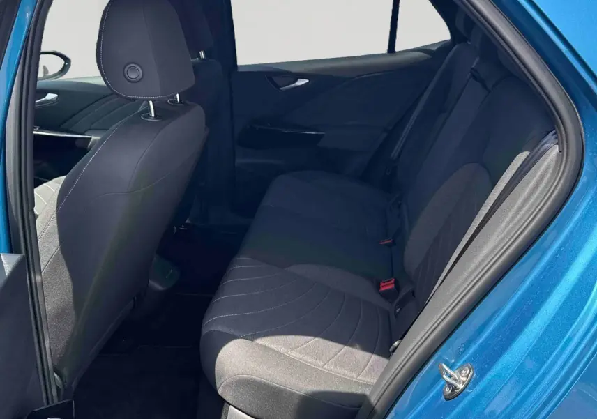 Vue intérieure côté droit sur la banquette arrière et la portière bleue d'un Volkswagen ID.3 2025 électrique.