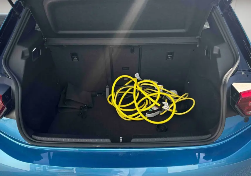 Coffre ouvert d'une Volkswagen ID.3 204 ch Pro S bleu, avec câble de recharge électrique jaune visible à l'intérieur.
