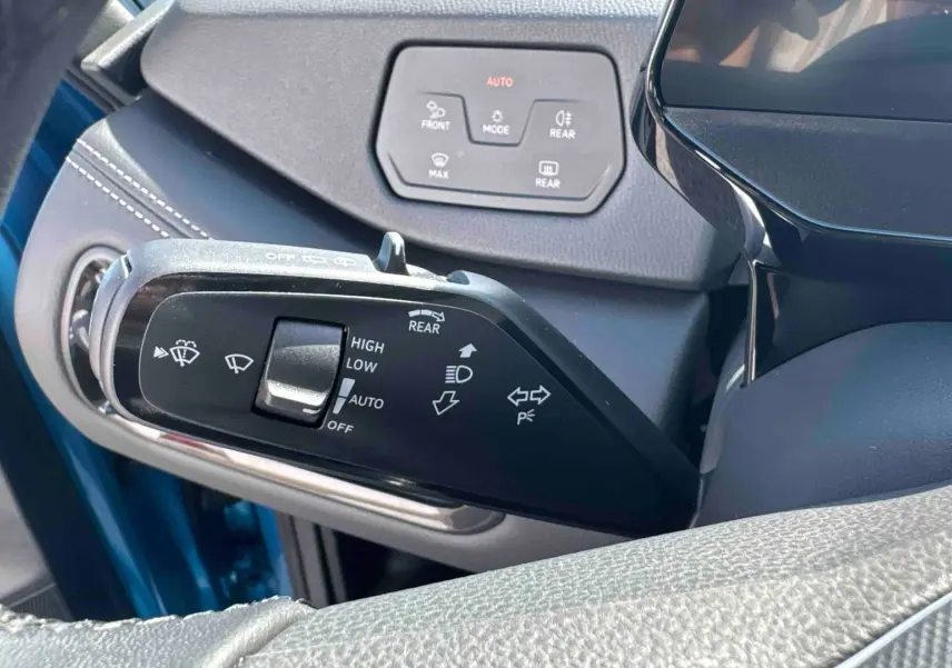 Détail du commodo d'éclairage et essuie-glace d'un Volkswagen ID.3 bleu, intérieur côté conducteur.