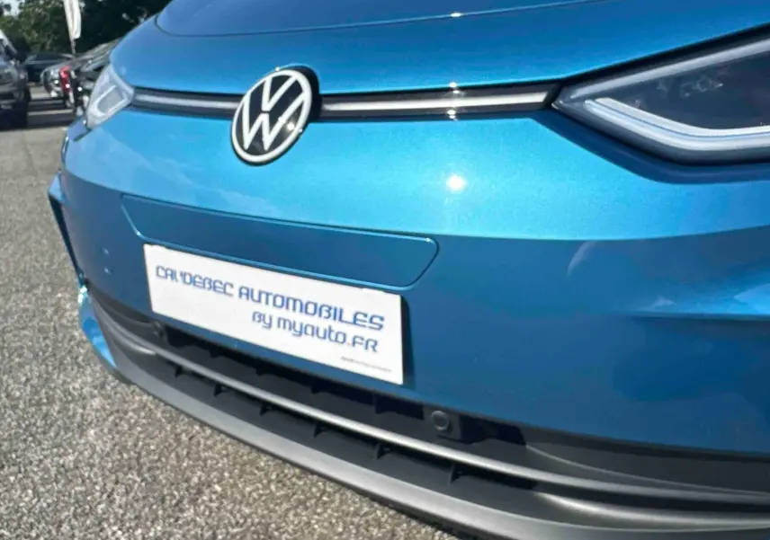 Vue rapprochée 3/4 avant du Volkswagen ID.3 bleu métallisé avec logo VW et calandre épurée noire.