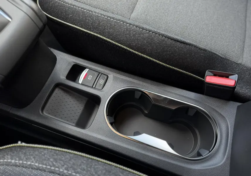 Gros plan sur la console centrale noire avec porte-gobelet, frein à main électrique et accoudoir du Renault Captur 2026.