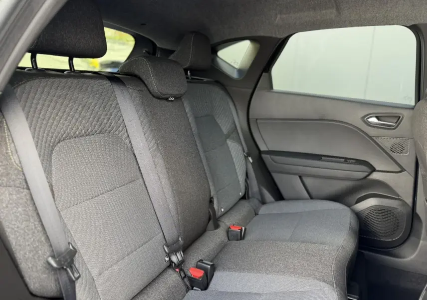 Vue intérieure côté droit des sièges arrière gris foncé du Renault Captur 2026 avec ceintures de sécurité et garnitures tissu.