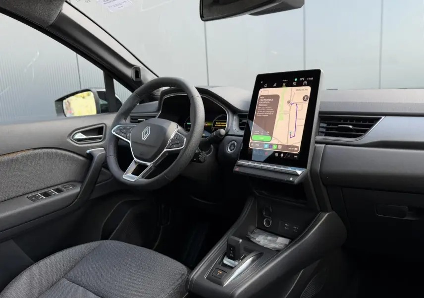 Vue intérieure côté conducteur du Renault Captur 2026 avec tableau de bord noir et écran tactile central vertical.