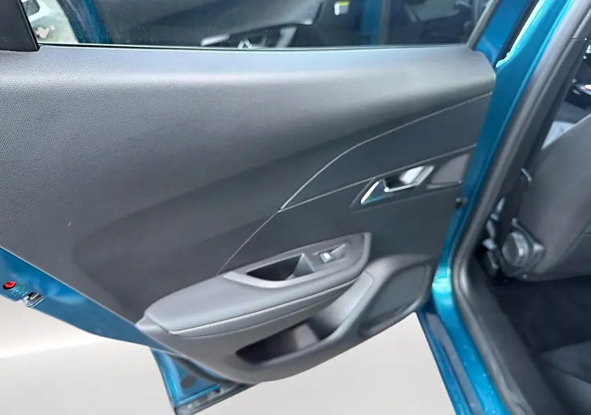 Vue intérieure sur la porte arrière gauche bleu obsession d'un Peugeot 2008 1.2 hybrid 145 allure e-dcs6 2026.