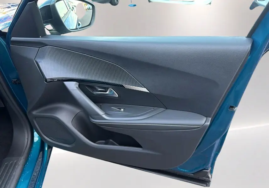 Vue intérieure de la porte avant gauche bleu obsession d'une Peugeot 2008 1.2 hybrid 145 allure e-dcs6 avec habillage noir et insert carbone.