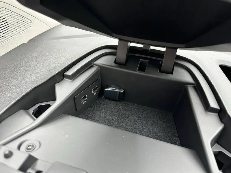 Vue rapprochée de la console centrale ouverte du Nissan Townstar blanc minéral, montrant ports USB et prise 12V.