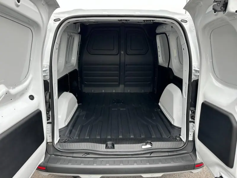 Vue arrière ouverte du Nissan Townstar L1 EV blanc minéral montrant l'espace de chargement vide avec cloison pleine noire.