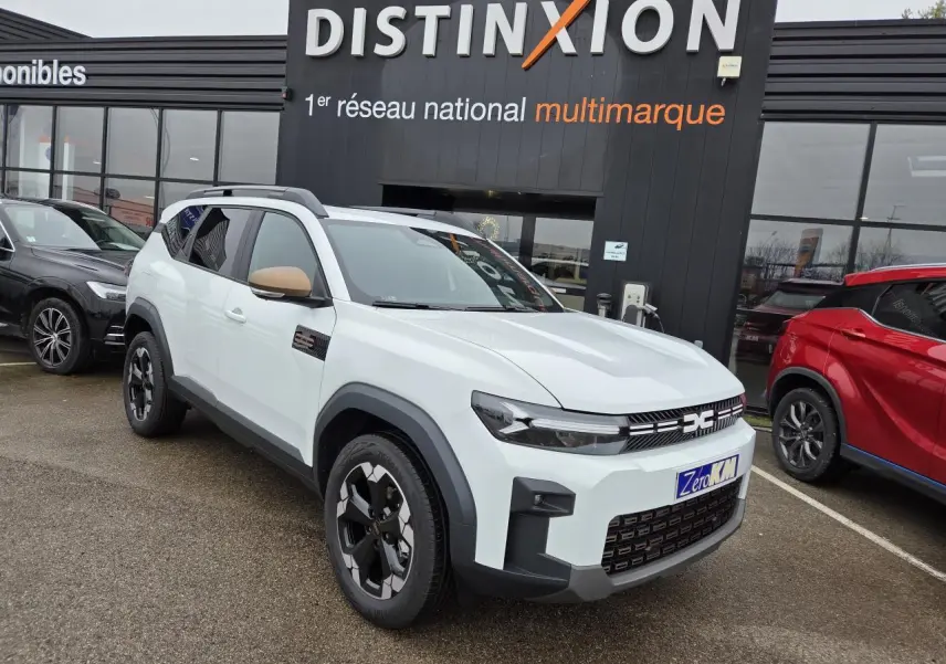 Dacia Bigster blanc glacier en 3/4 avant droit avec rétroviseurs brun cuivré et jantes noires semi-diamantées.