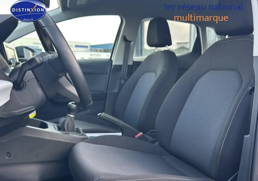 Vue intérieure côté conducteur de la SEAT Ibiza 1.0 TSI 95 Copa avec sièges tissu gris et volant cuir méplat.