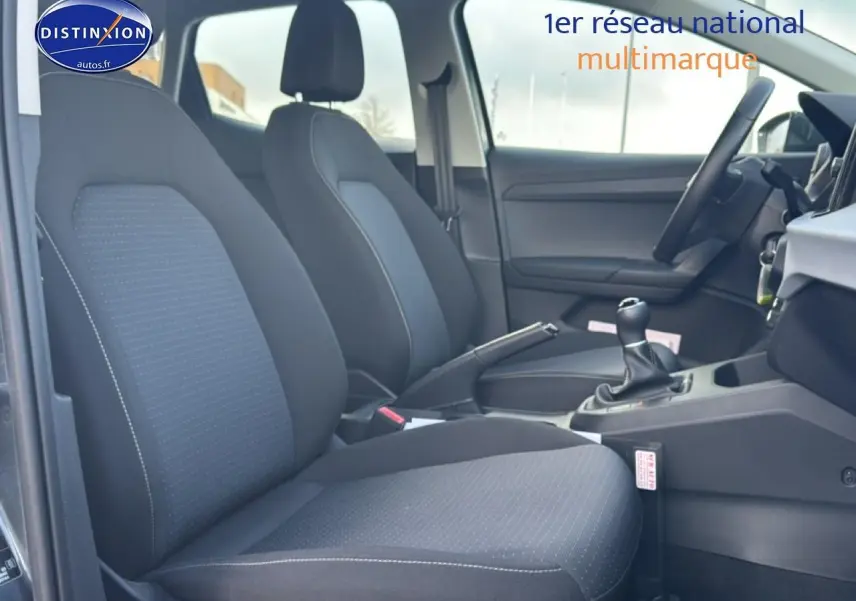 Vue intérieure côté conducteur de la SEAT Ibiza 1.0 TSI 95 Copa avec sièges tissu gris et volant multifonction.