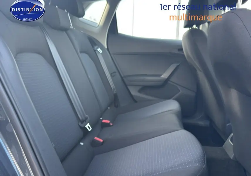 Vue latérale droite de la banquette arrière en tissu gris de la SEAT Ibiza 2025, avec trois appuie-têtes et ceintures visibles.