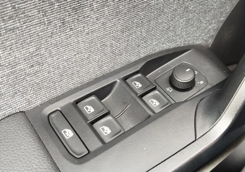 Panneau de commandes des vitres électriques et réglage des rétroviseurs dans une SEAT Arona blanc Candy 2023.