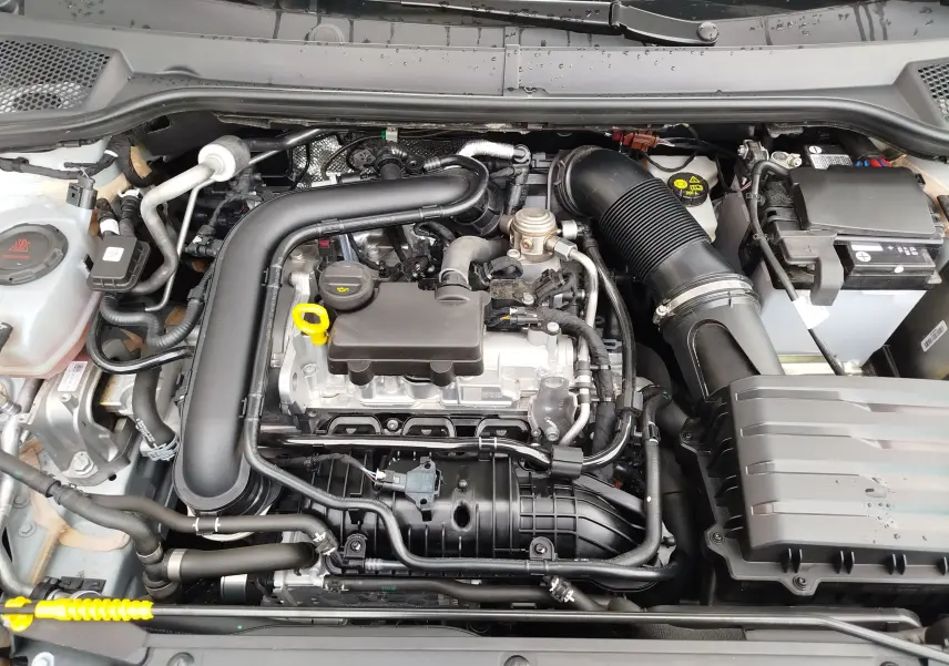 Vue rapprochée du moteur essence 1.0 TSI du SEAT Arona 2023, montrant les composants sous le capot ouvert.