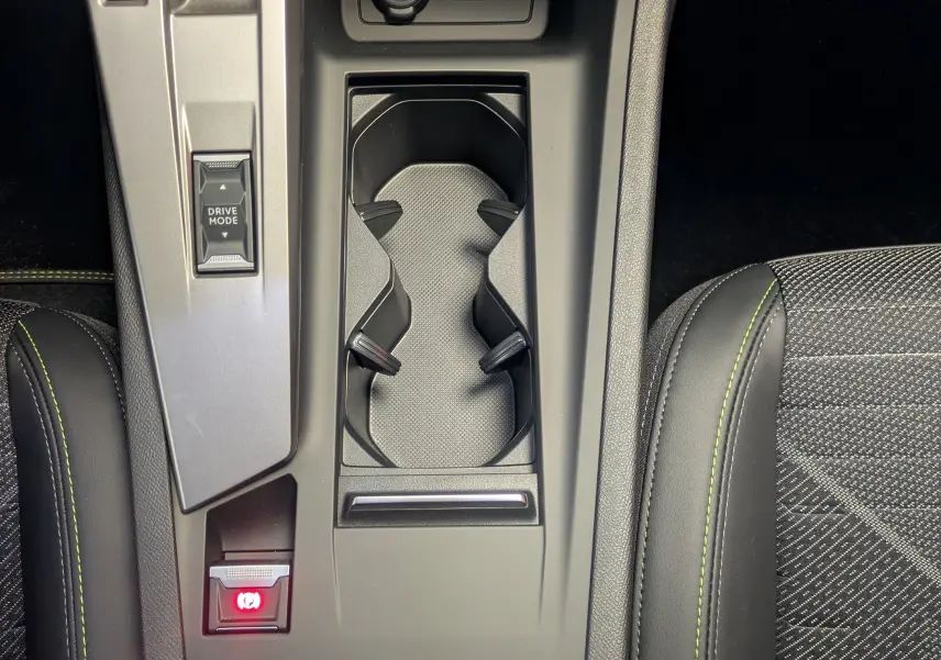 Vue plongeante sur la console centrale intérieure de la Peugeot 308 gris selenium, avec levier de vitesses automatique et porte-gobelets.