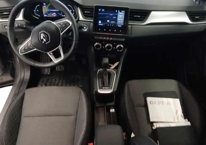 Vue intérieure du tableau de bord et console centrale du Renault Captur gris Cassiopée, avec écran tactile et volant multifonction.