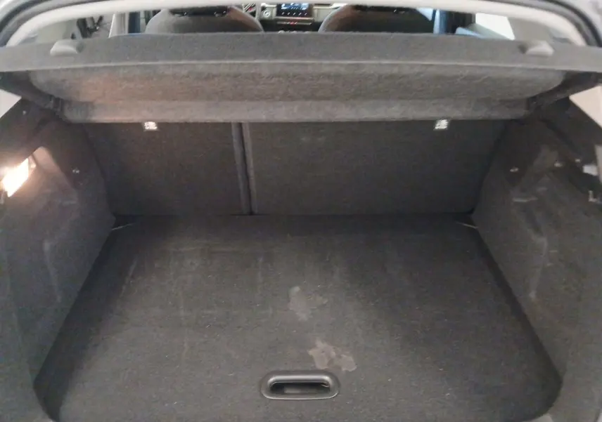 Coffre ouvert vu de l'intérieur d’un Renault Captur E-Tech gris Cassiopée, montrant l’espace de chargement vide.