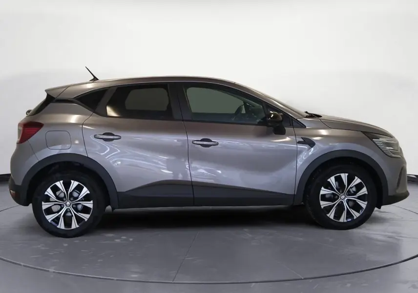 Profil droit du Renault Captur 2023 gris Cassiopée hybride avec jantes alliage distinctives.
