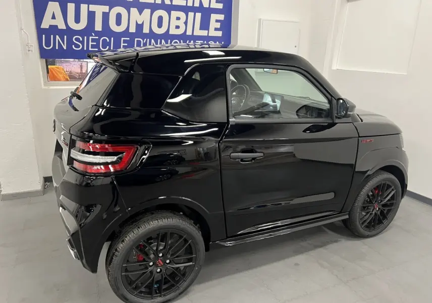 Vue 3/4 arrière droite de la LIGIER JS50 noire avec jantes alu noires mates et badge Ultimate sur l'aile avant.