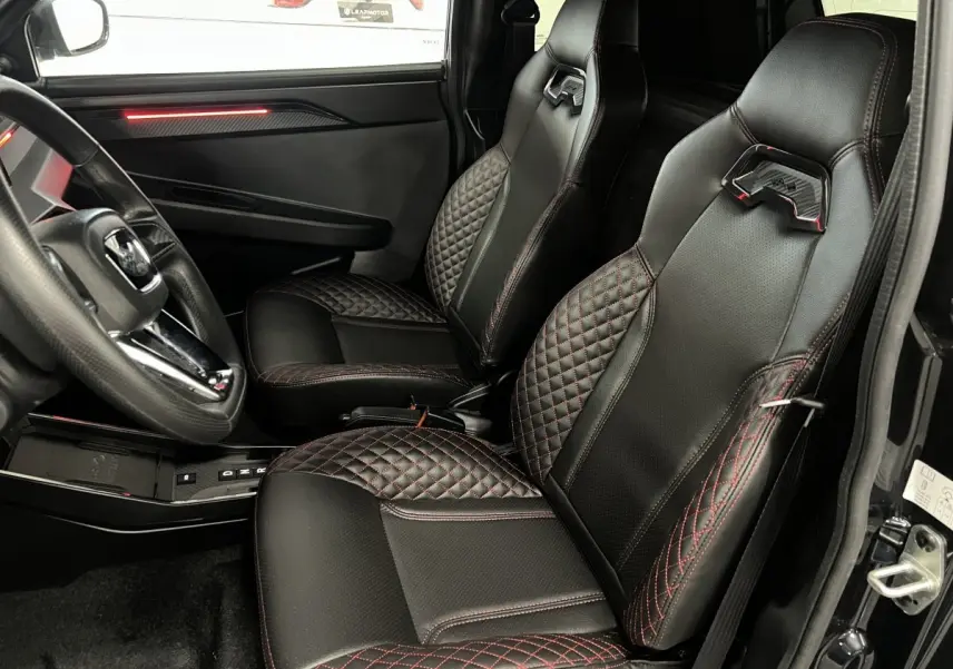 Vue intérieure côté conducteur de la LIGIER JS50 noire, sièges Ultimate en cuir noir avec surpiqûres rouges.