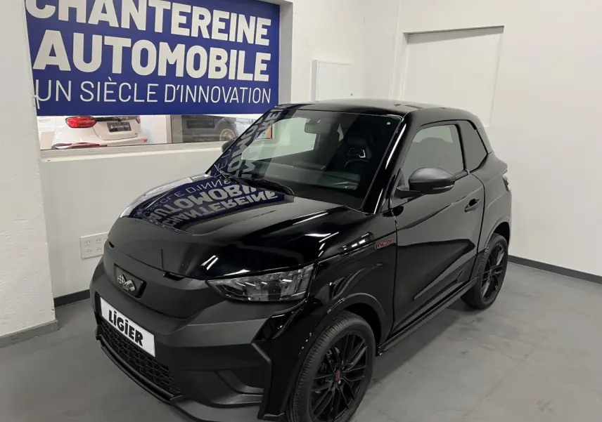 Vue 3/4 avant d'une LIGIER JS50 noire mate avec jantes alu noires et badge Ultimate sur l'aile avant droite.