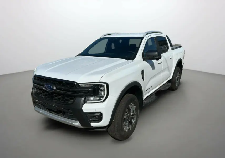 Ford Ranger blanc en 3/4 avant droit, avec calandre noire et barres de toit visibles sur fond neutre.