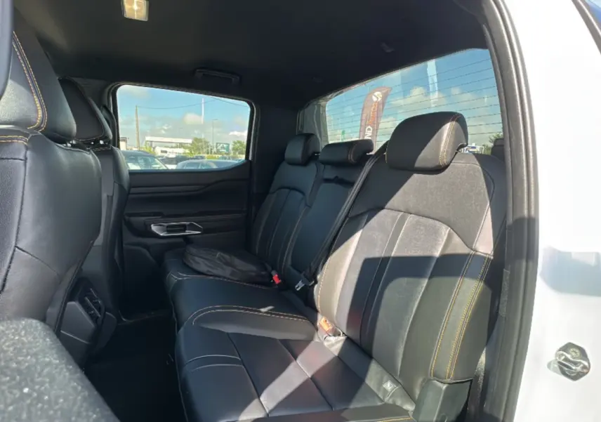 Vue intérieure côté droit sur la banquette arrière en cuir noir avec surpiqûres jaunes du Ford Ranger blanc 2026.