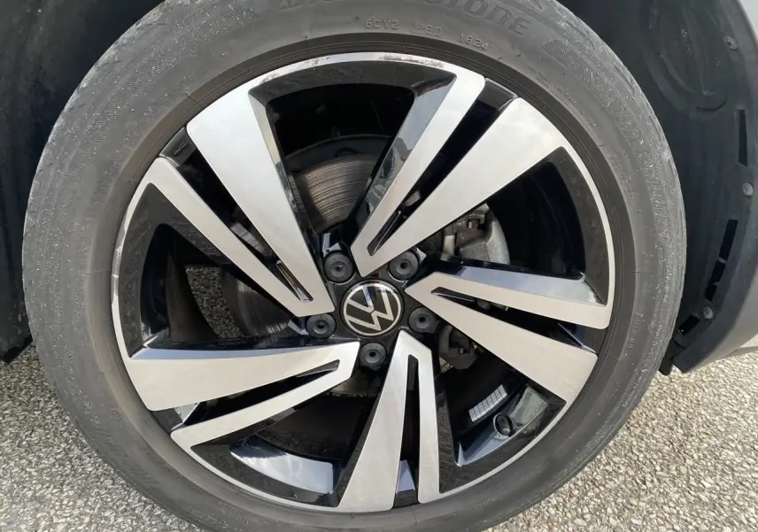 Gros plan sur la jante alliage Nevada noire et argentée du Volkswagen T-Roc 2024, détail du pneu Bridgestone.