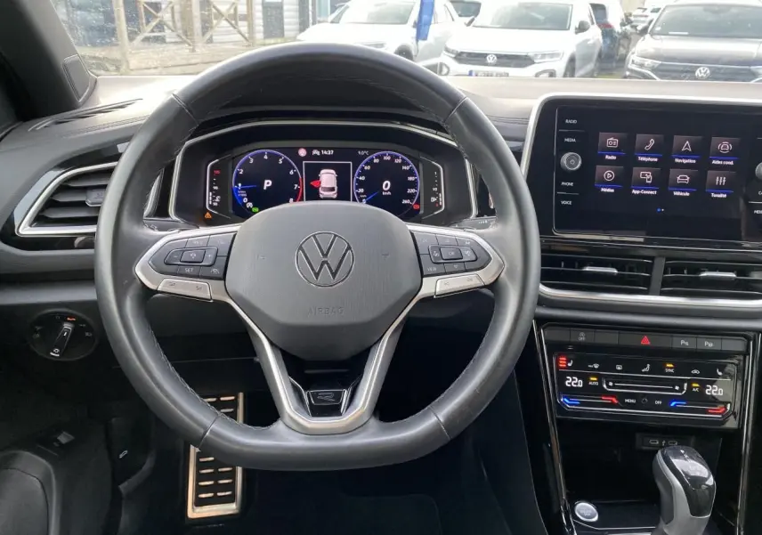 Vue intérieure centrée sur le volant cuir noir et le tableau de bord digital du Volkswagen T-Roc 2024.