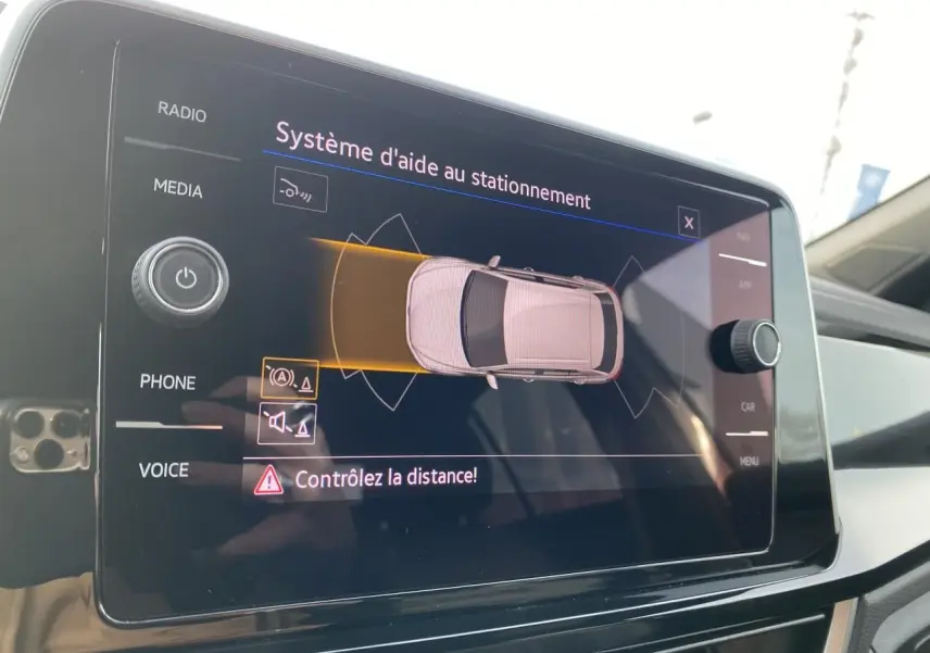 Écran tactile du système d'aide au stationnement dans l'habitacle d'une Volkswagen T-Roc gris, vue intérieure.