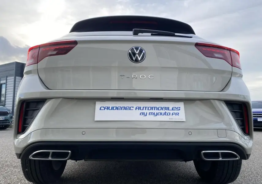 Vue arrière d'un Volkswagen T-Roc gris 2024 avec double sortie d'échappement rectangulaire et feux LED rouges.