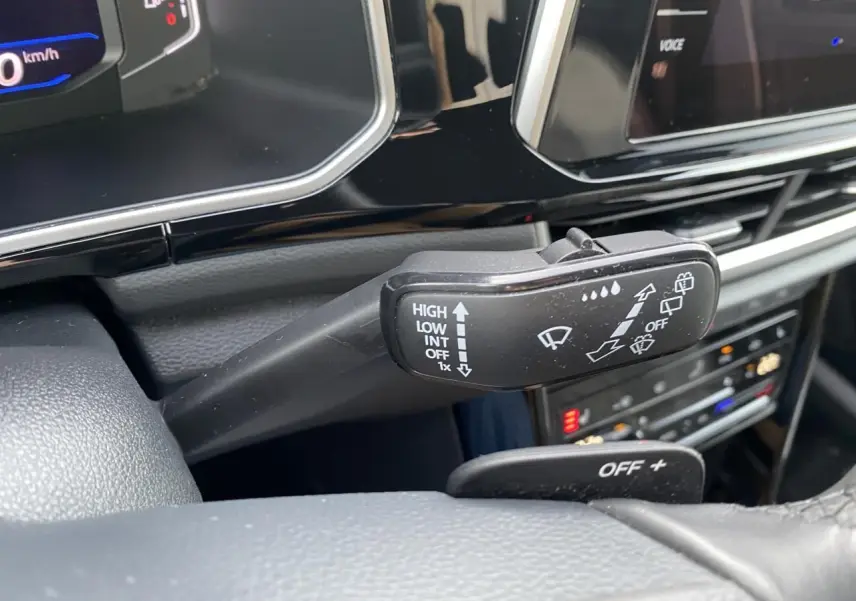 Gros plan sur la commande des essuie-glaces dans l'habitacle noir du Volkswagen T-Roc 2024.