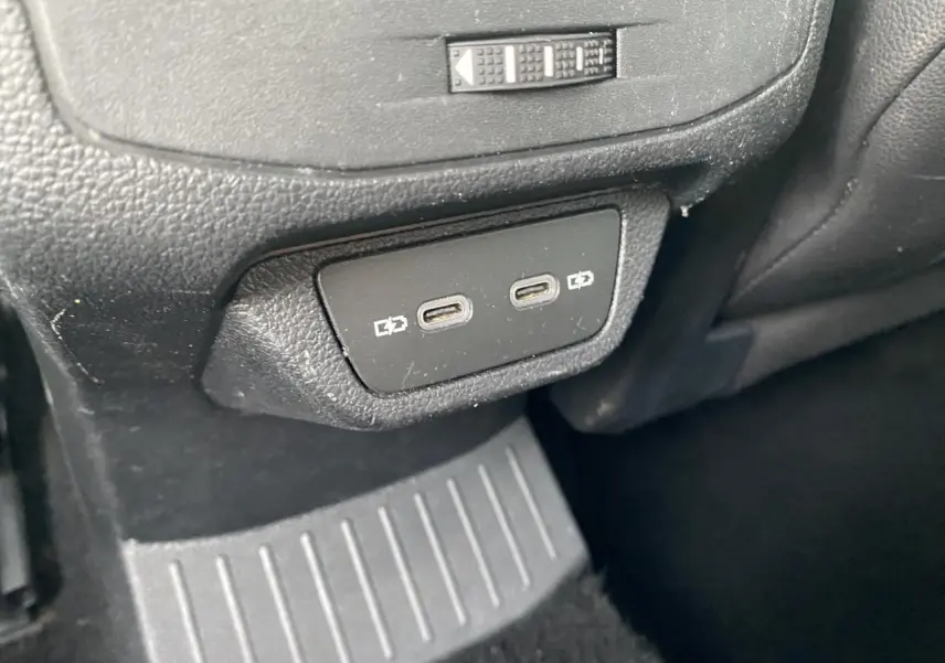 Vue rapprochée des deux ports USB-C de recharge arrière sur la console centrale noire du Volkswagen T-Roc 2024.