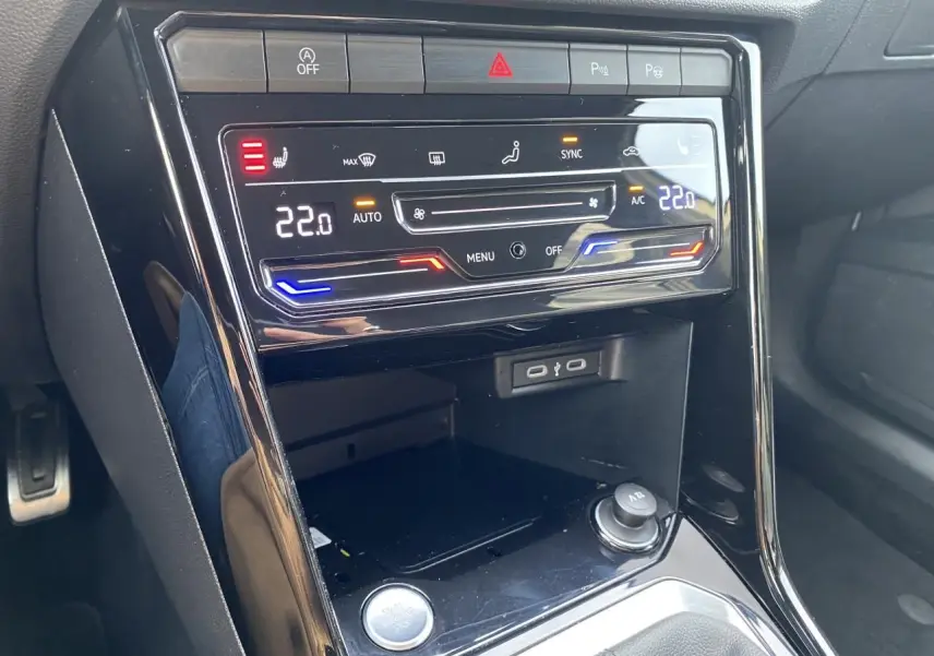 Vue rapprochée de la console centrale noire du Volkswagen T-Roc 2024 avec climatisation digitale et commandes tactiles.