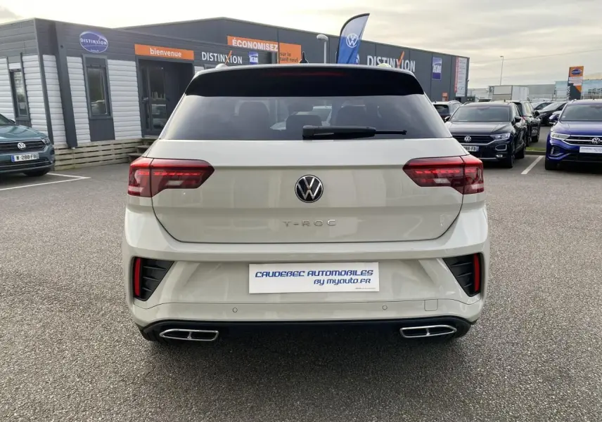 Vue arrière d’un Volkswagen T-Roc gris clair avec feux LED et double sortie d’échappement rectangulaire chromée.