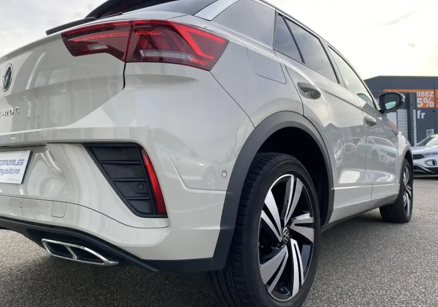 Vue 3/4 arrière droite du Volkswagen T-Roc gris clair avec jantes alliage Nevada noires et feux arrière LED.