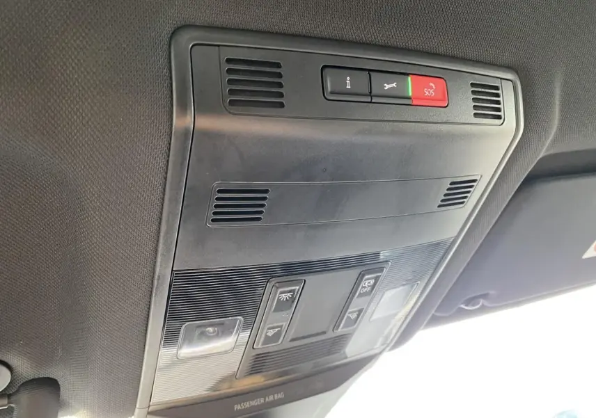 Vue en gros plan du plafonnier intérieur noir du Volkswagen T-Roc 2024 avec boutons SOS et éclairage.