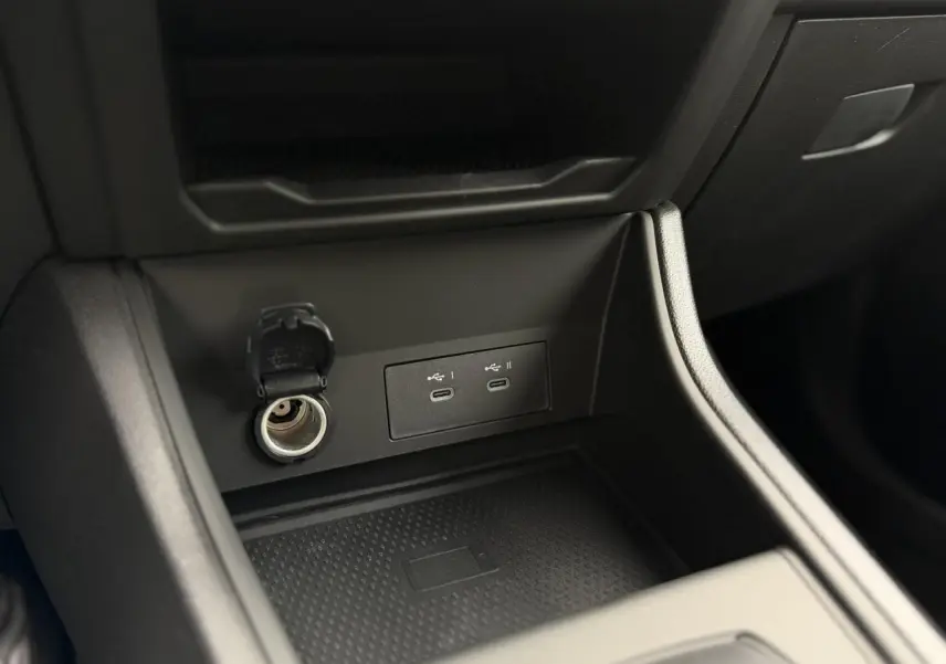 Gros plan sur la console centrale du Renault Captur 2026, montrant prises USB-C, allume-cigare et chargeur induction noir.