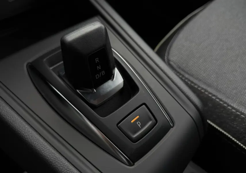 Gros plan sur la commande de boîte automatique noire et bouton de parking orange dans l’habitacle du Renault Captur 2026.